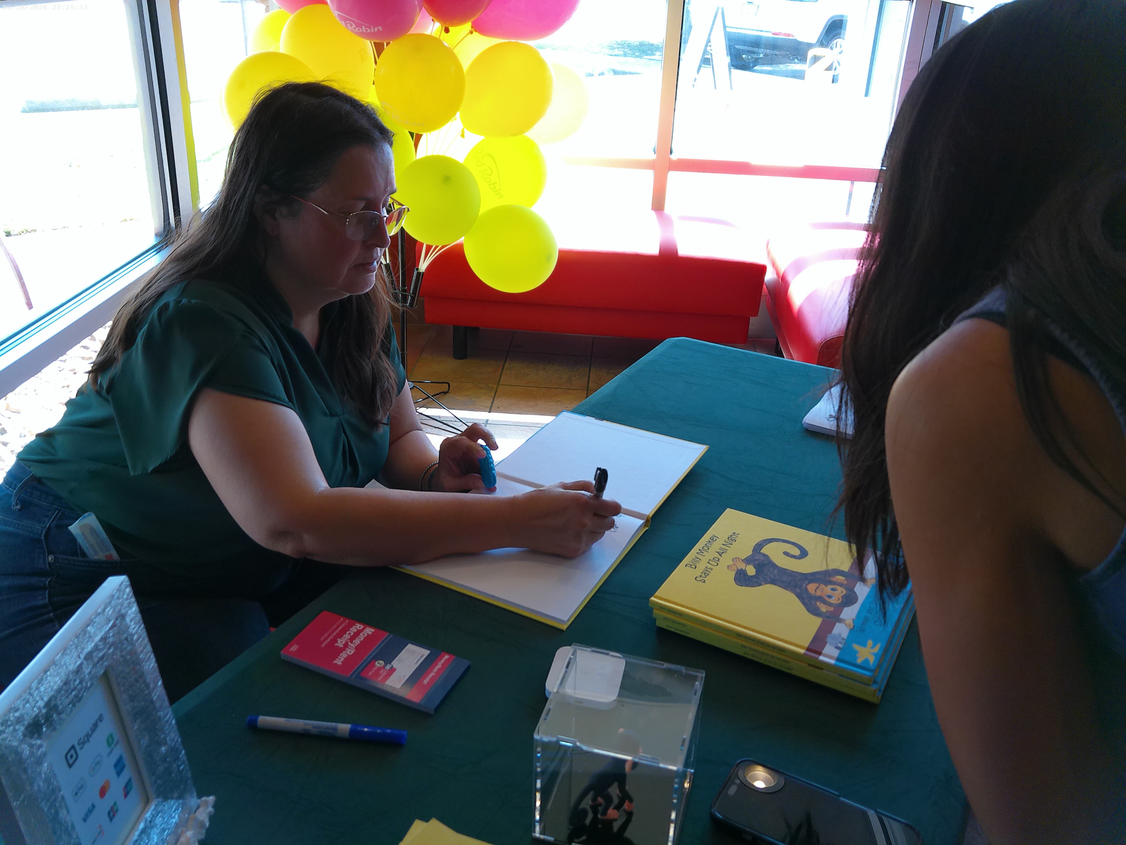 Sheri Sanderson signing a copy of Billy Monkey Stays Up All Night
